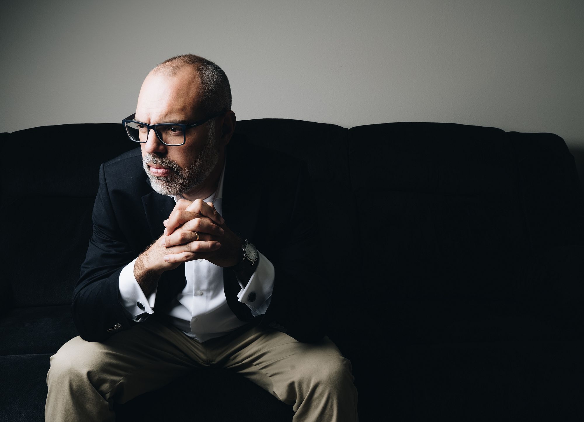 Portrait of Allan Dos Santos seated on a sofa
